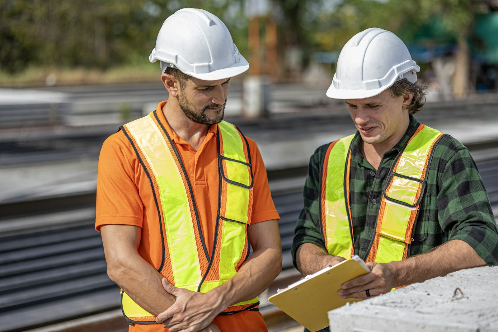 Engineers reviewing construction drawings with a contractor on site.