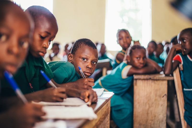 Secondary-school students writing in books during a session.